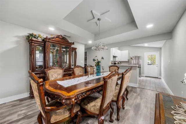 a dining room with furniture a chandelier and wooden floor