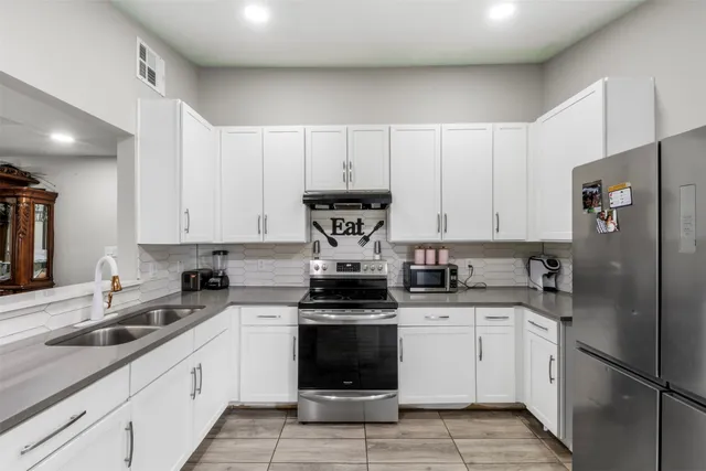 a kitchen with a sink a counter top space stainless steel appliances and cabinets