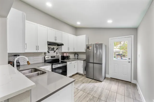 a kitchen with a sink stove top oven and cabinets