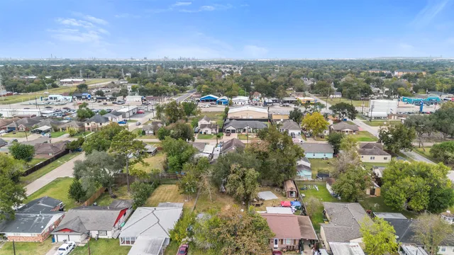 an aerial view of residential houses with outdoor space and trees