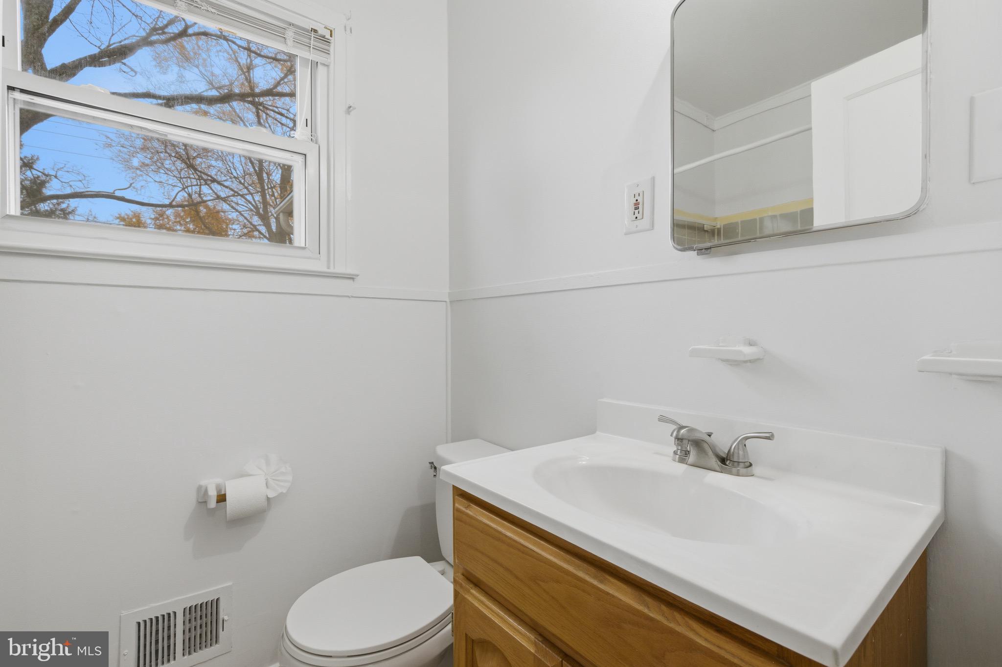 1004 Marton Street Laurel, MD 20707 - Photo 13 of 21 a bathroom with a sink a toilet and mirror