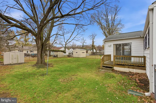 a view of a house with backyard and a tree