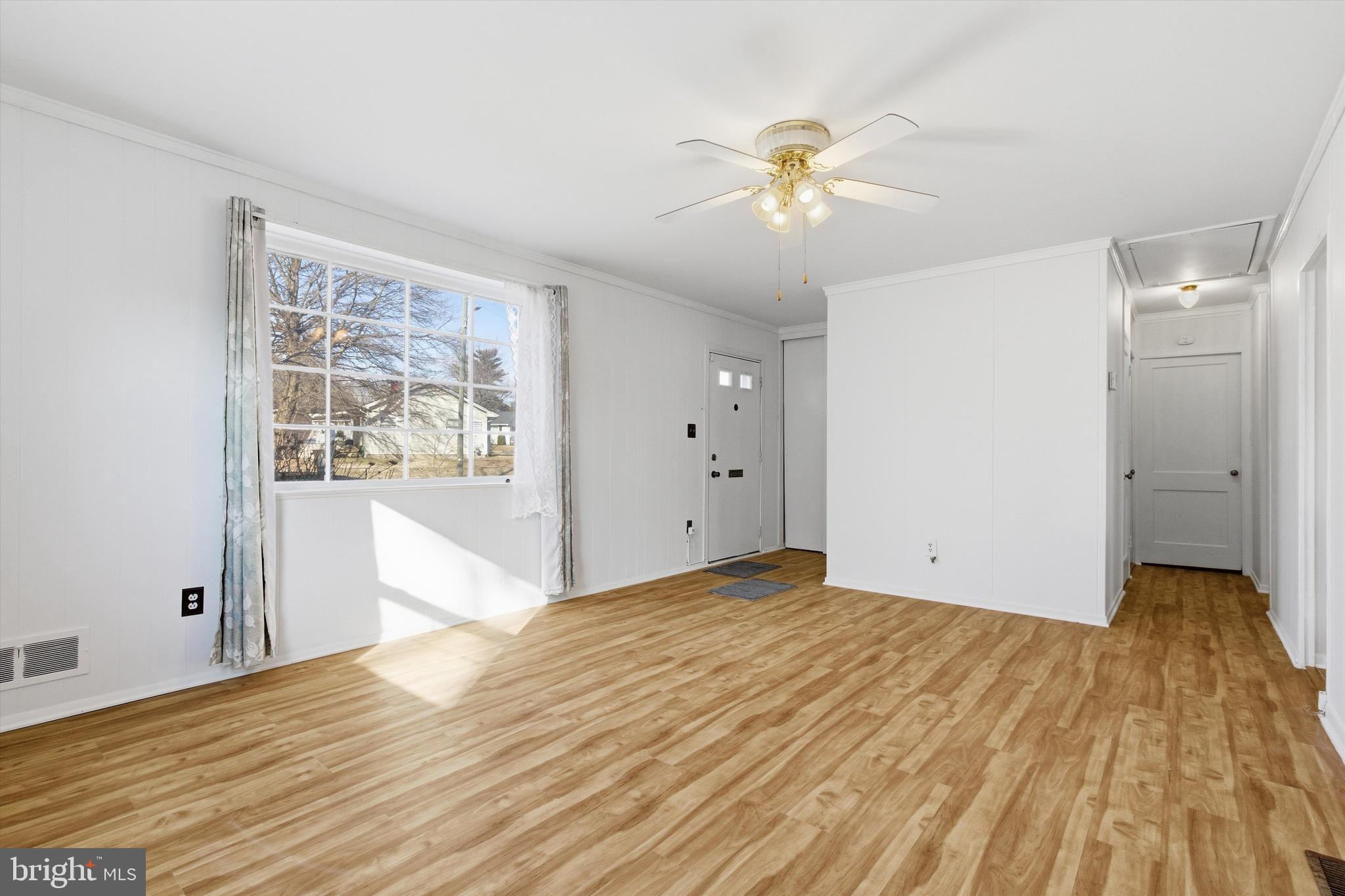1004 Marton Street Laurel, MD 20707 - Photo 4 of 21 a view of a livingroom with wooden floor and a ceiling fan