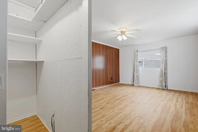 a view of an empty room with a ceiling fan and a window