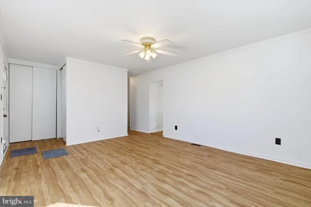 a view of a room with wooden floor and a ceiling fan