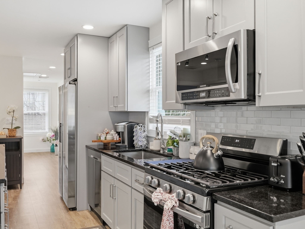 149 Pleasant Street, Unit 2 Marblehead, MA 01945 - Photo 11 of 41 a kitchen with stainless steel appliances a stove a microwave and cabinets