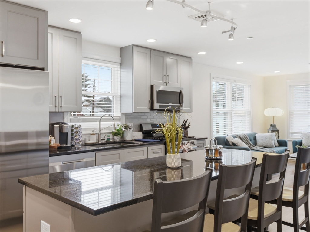149 Pleasant Street, Unit 2 Marblehead, MA 01945 - Photo 13 of 41 a kitchen with kitchen island granite countertop a sink and counter space