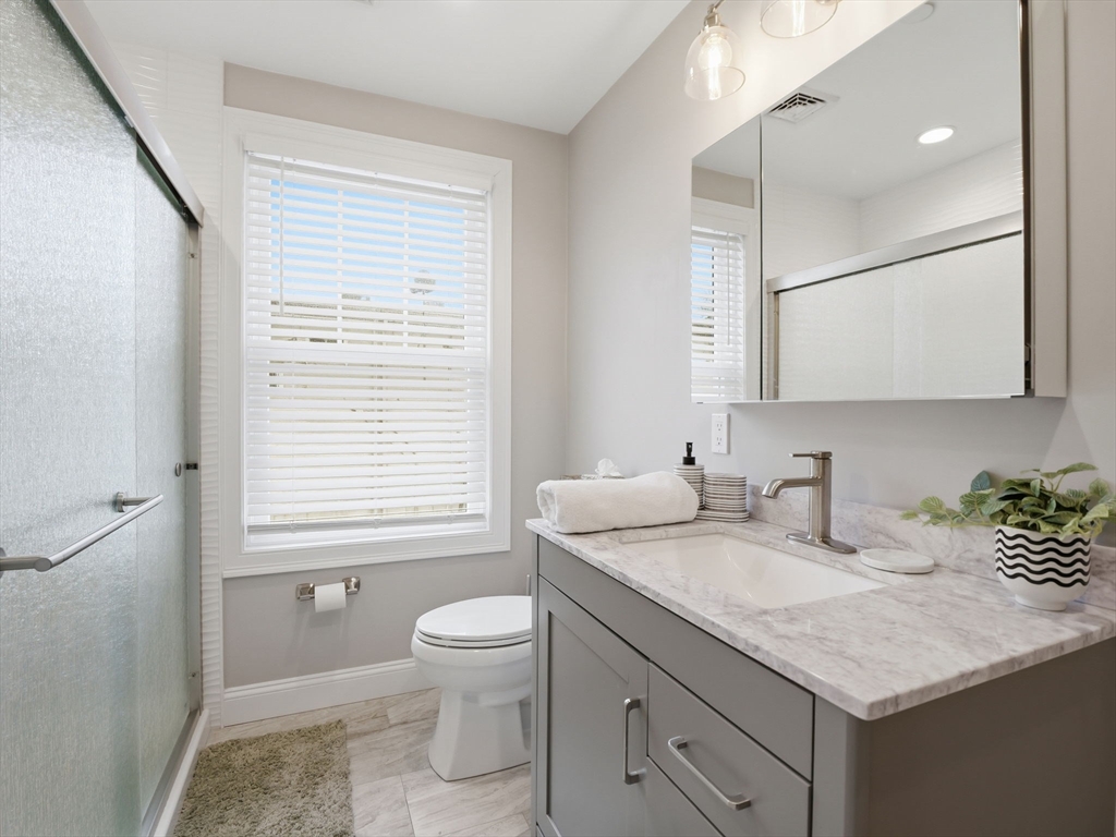 149 Pleasant Street, Unit 2 Marblehead, MA 01945 - Photo 20 of 41 a bathroom with a granite countertop sink toilet and a mirror