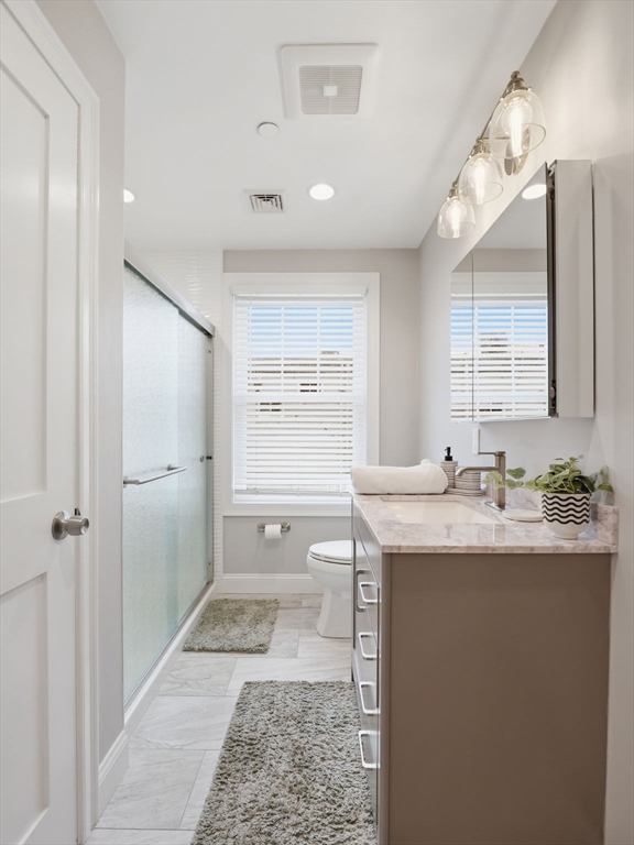 149 Pleasant Street, Unit 2 Marblehead, MA 01945 - Photo 21 of 41 a bathroom with a granite countertop sink a toilet and mirror