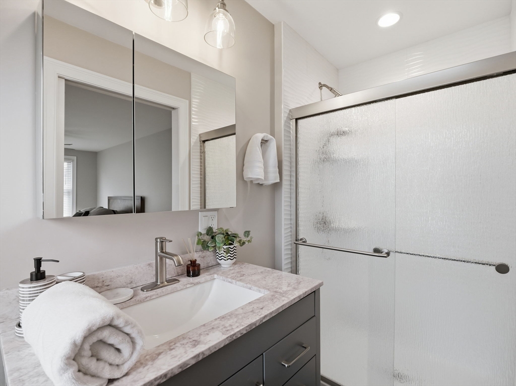 149 Pleasant Street, Unit 2 Marblehead, MA 01945 - Photo 27 of 41 a bathroom with a granite countertop sink mirror and vanity