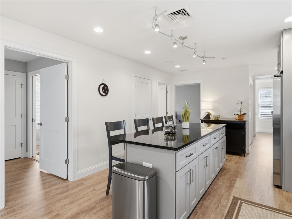 149 Pleasant Street, Unit 2 Marblehead, MA 01945 - Photo 6 of 41 a kitchen with stainless steel appliances kitchen island granite countertop a sink and cabinets