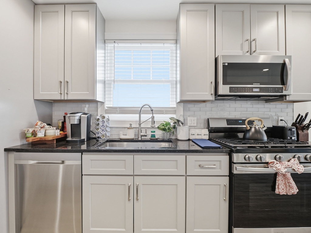 149 Pleasant Street, Unit 2 Marblehead, MA 01945 - Photo 10 of 41 a kitchen with stainless steel appliances granite countertop a sink and a stove