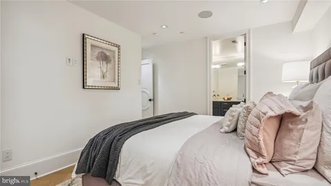 a bedroom with a bed lamp and a large window