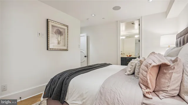 a bedroom with a bed lamp and a large window