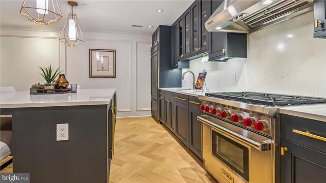 a kitchen with stainless steel appliances a sink stove and cabinets