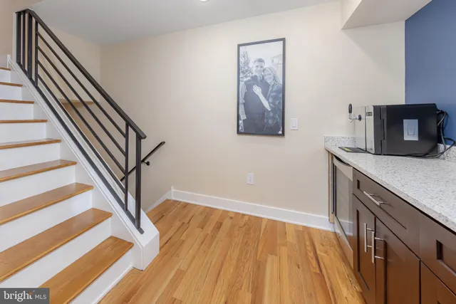 a view of a hallway with wooden floor and staircase