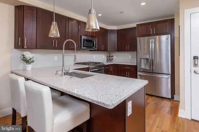 a kitchen with a sink a refrigerator and wooden cabinets