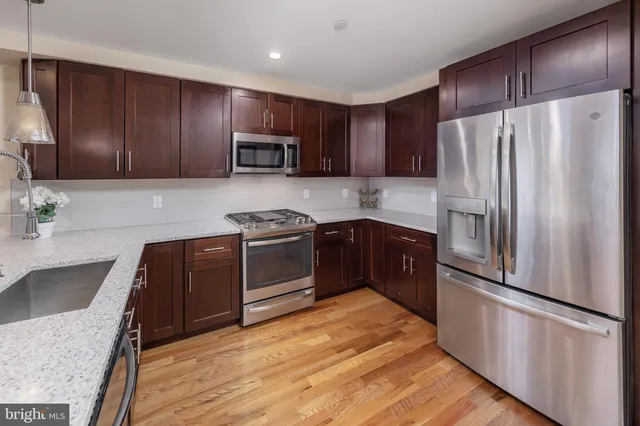 a kitchen with granite countertop stainless steel appliances and wooden cabinets
