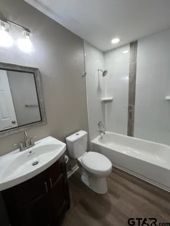 a bathroom with a sink toilet a mirror and shower