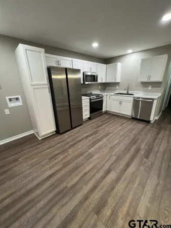 a large kitchen with stainless steel appliances granite countertop a stove a sink and a refrigerator