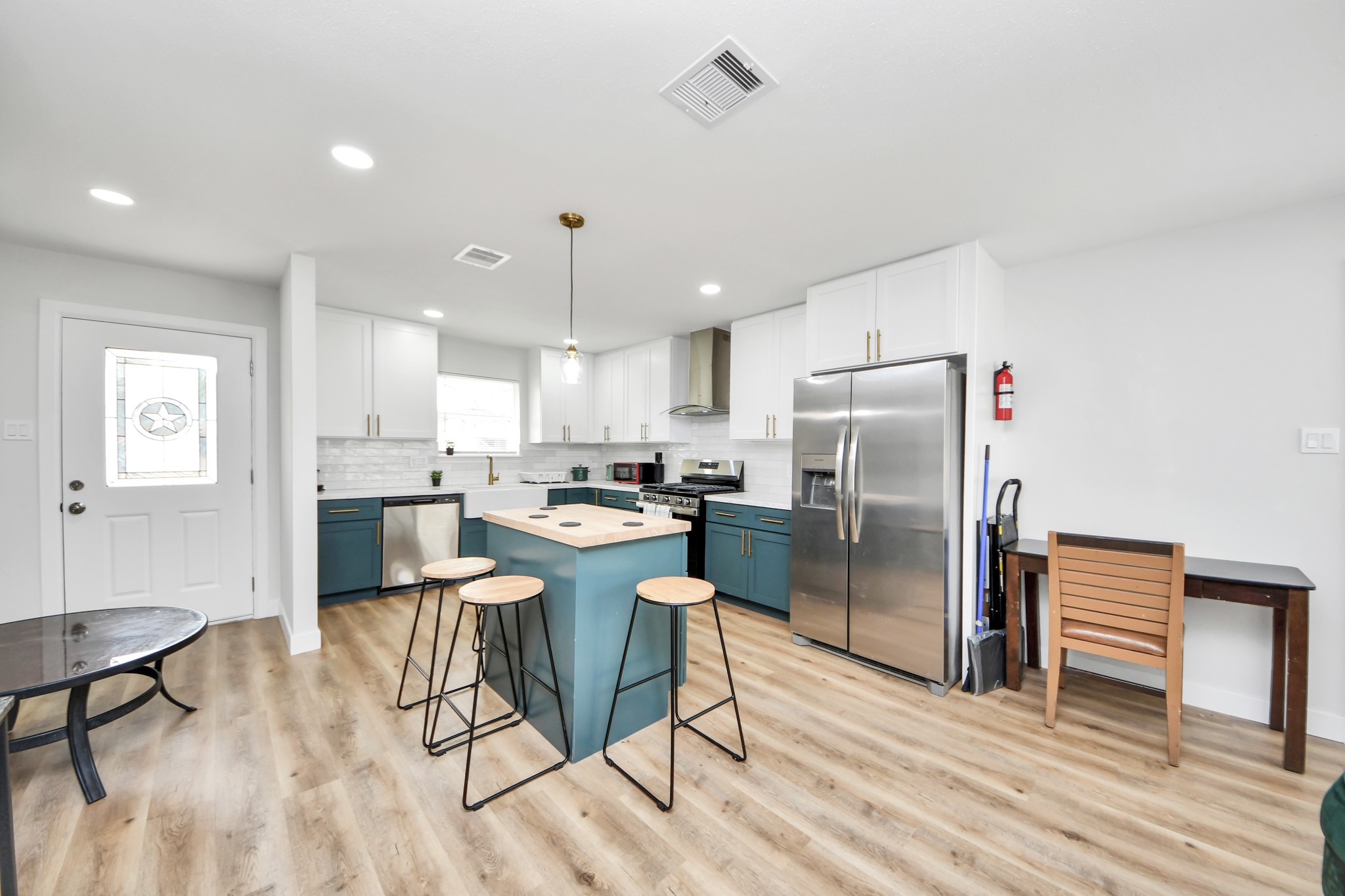 5115 Clay Street Houston, TX 77023 - Photo 2 of 43 a kitchen with stainless steel appliances granite countertop a refrigerator a stove top oven and a dining table with wooden floor