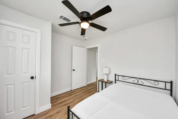 a view of a bedroom with a bed and wooden floor