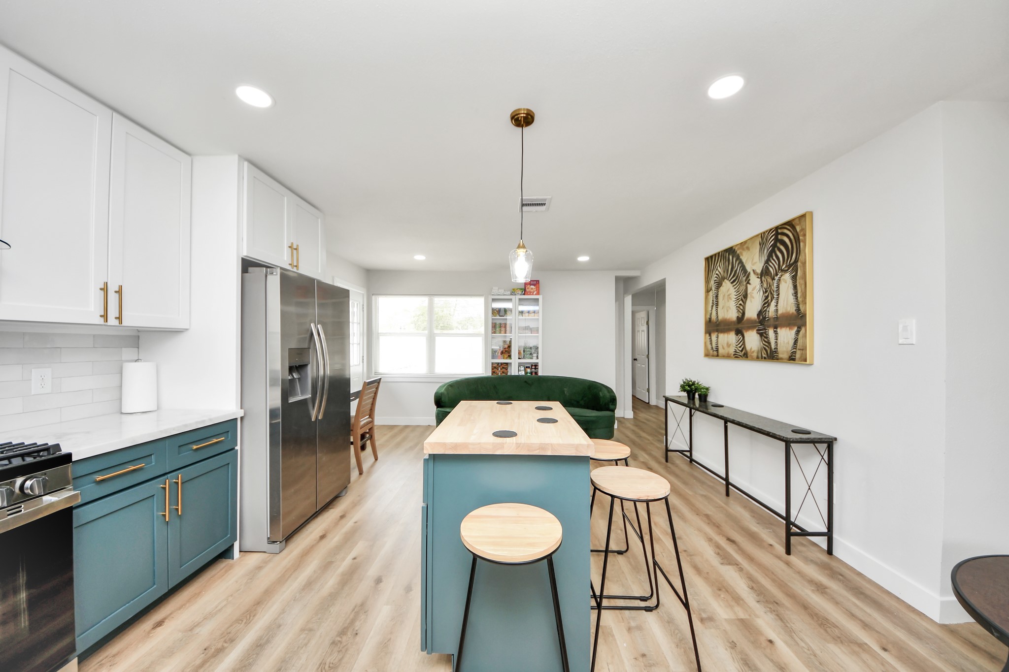 5115 Clay Street Houston, TX 77023 - Photo 7 of 43 a kitchen with stainless steel appliances granite countertop a refrigerator a sink dishwasher a stove and a dining table with wooden floor