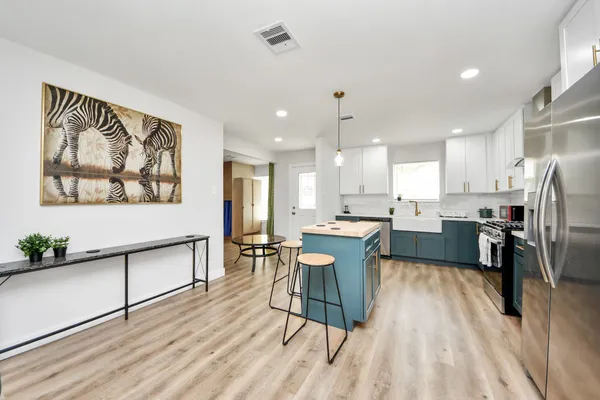 a kitchen with a table chairs refrigerator and microwave