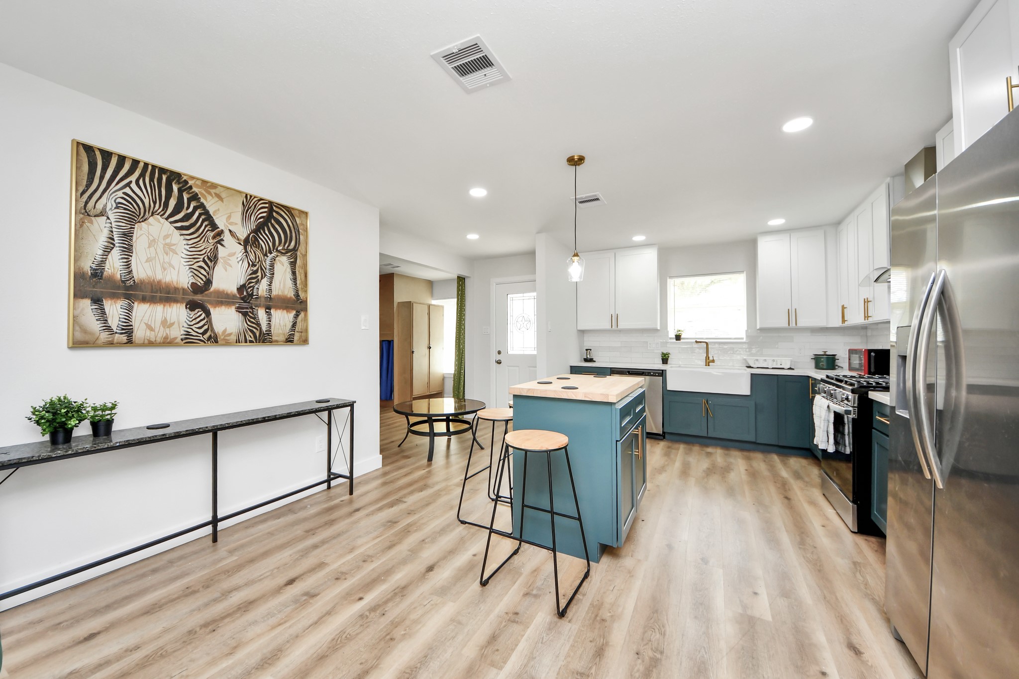 5115 Clay Street Houston, TX 77023 - Photo 8 of 43 a kitchen with a table chairs refrigerator and microwave