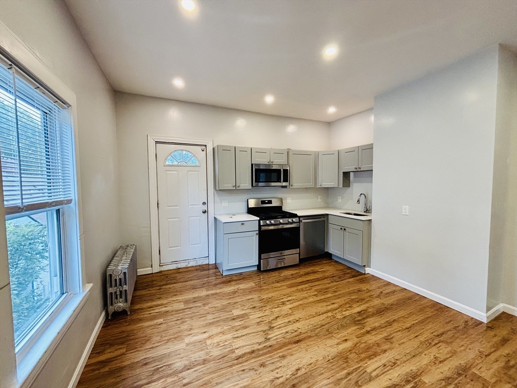 a kitchen with stainless steel appliances granite countertop a refrigerator and a stove top oven