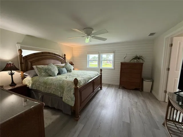 a spacious bedroom with a bed and a dresser in it