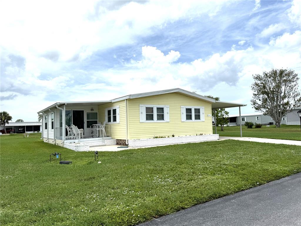 637 Los Altos, Unit 374 North Port, FL 34287 - Photo 2 of 26 a front view of a house with a garden and yard
