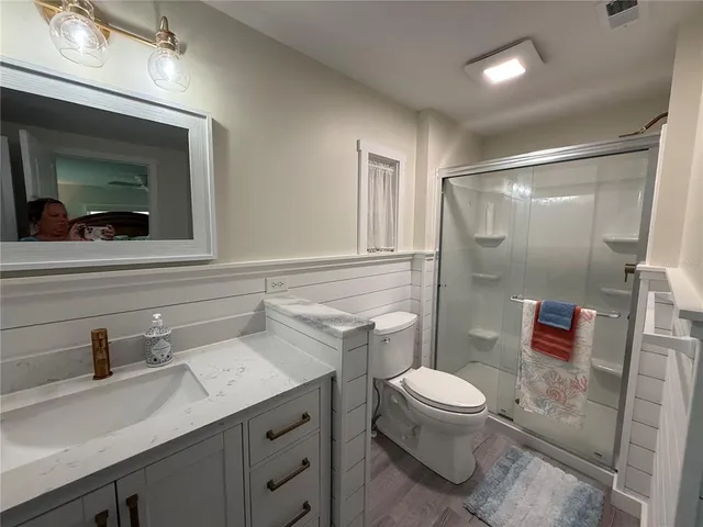 a bathroom with a sink a toilet a mirror and shower