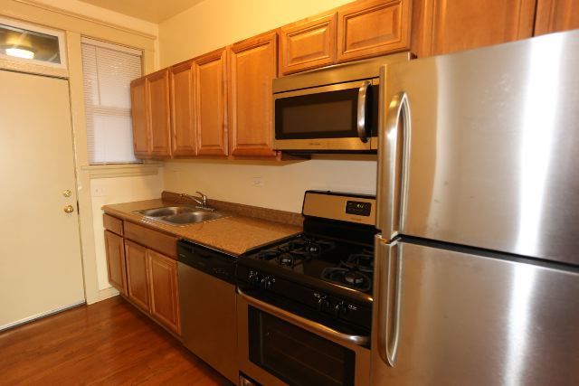 4716 North Racine Avenue, Unit 2E Chicago, IL 60640 - Photo 4 of 19 a kitchen with stainless steel appliances granite countertop a refrigerator stove and microwave