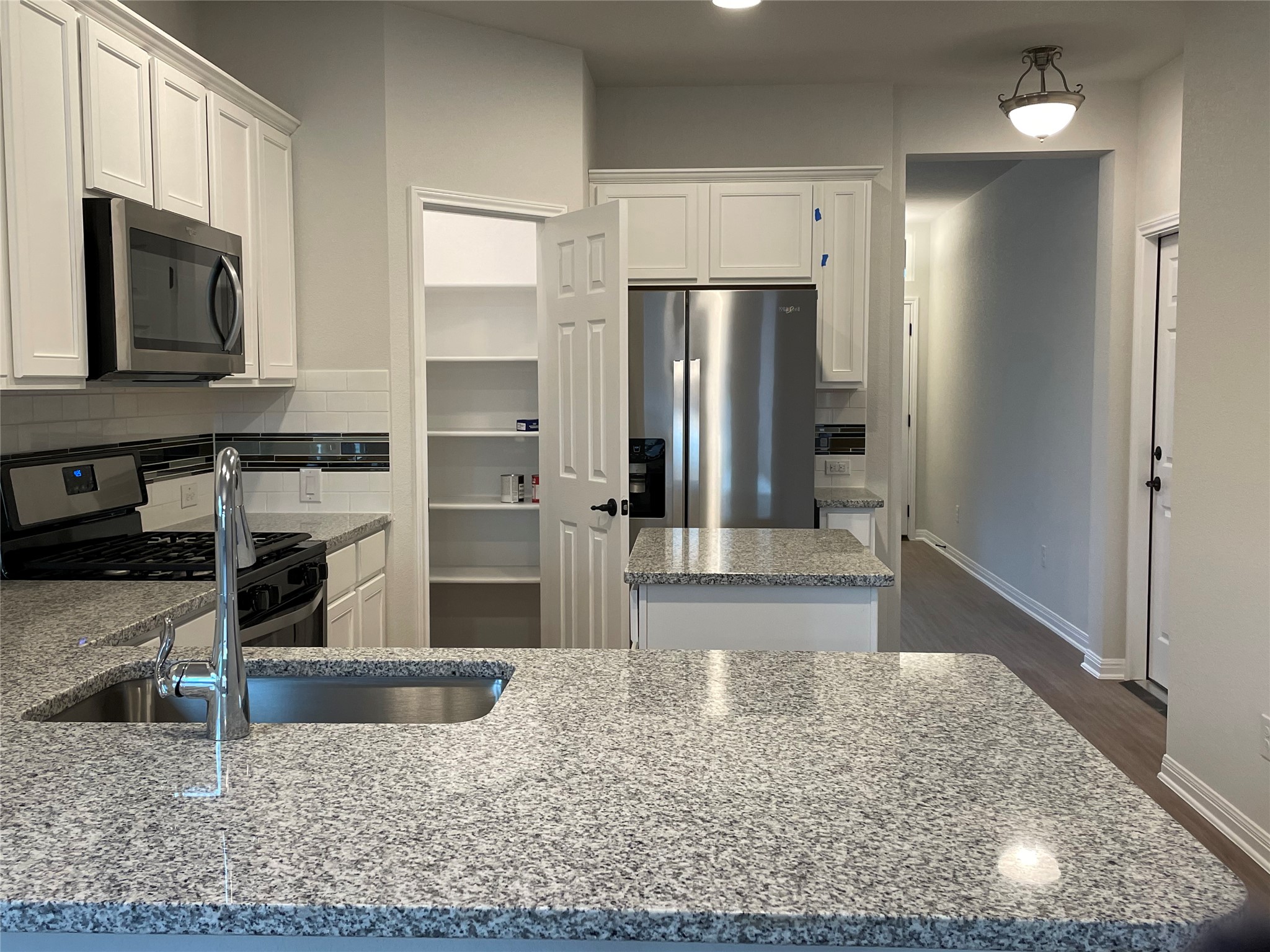 3908 Birdwatch Loop, Unit 56 Pflugerville, TX 78660 - Photo 9 of 30 a kitchen with stainless steel appliances granite countertop a refrigerator and a sink