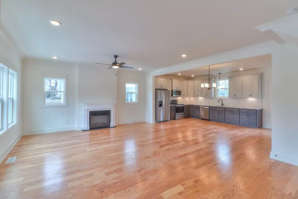 a view of an empty room and a kitchen with kitchen area window