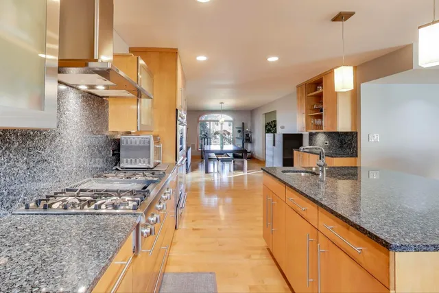a kitchen with stainless steel appliances granite countertop a stove and a sink