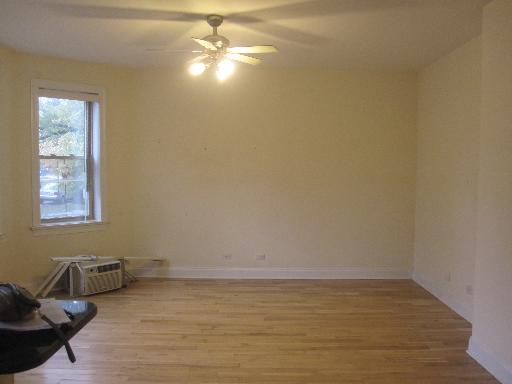 4540 West George Street, Unit 1 Chicago, IL 60641 - Photo 3 of 10 a view of empty room with wooden floor and fan