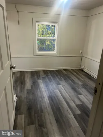 a view of a room with wooden floor and window