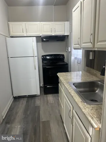 a kitchen with granite countertop a sink and a stove top oven
