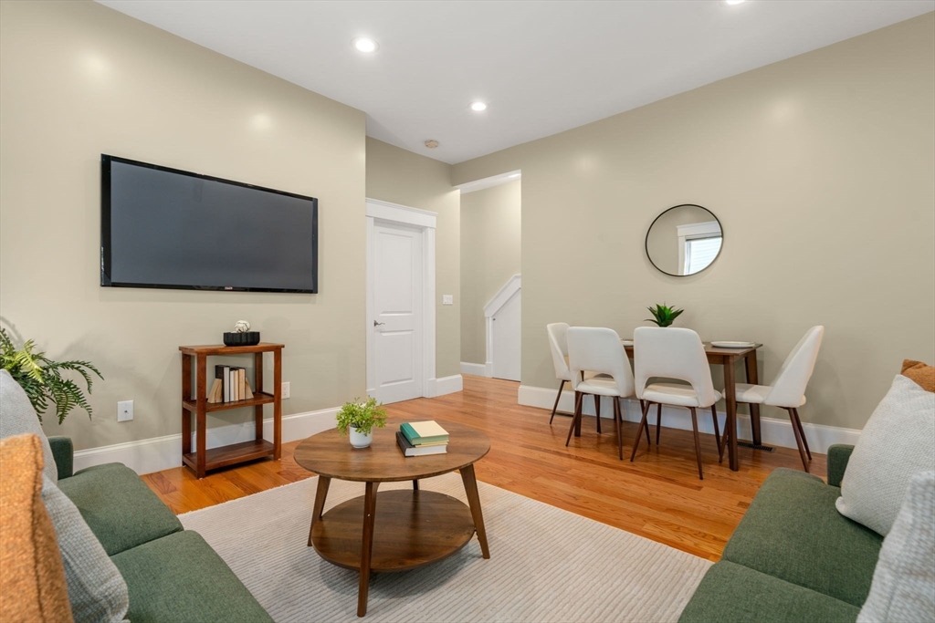 19 Pinckney Street, Unit 1 Somerville, MA 02145 - Photo 15 of 39 a living room with furniture a flat screen tv and kitchen view