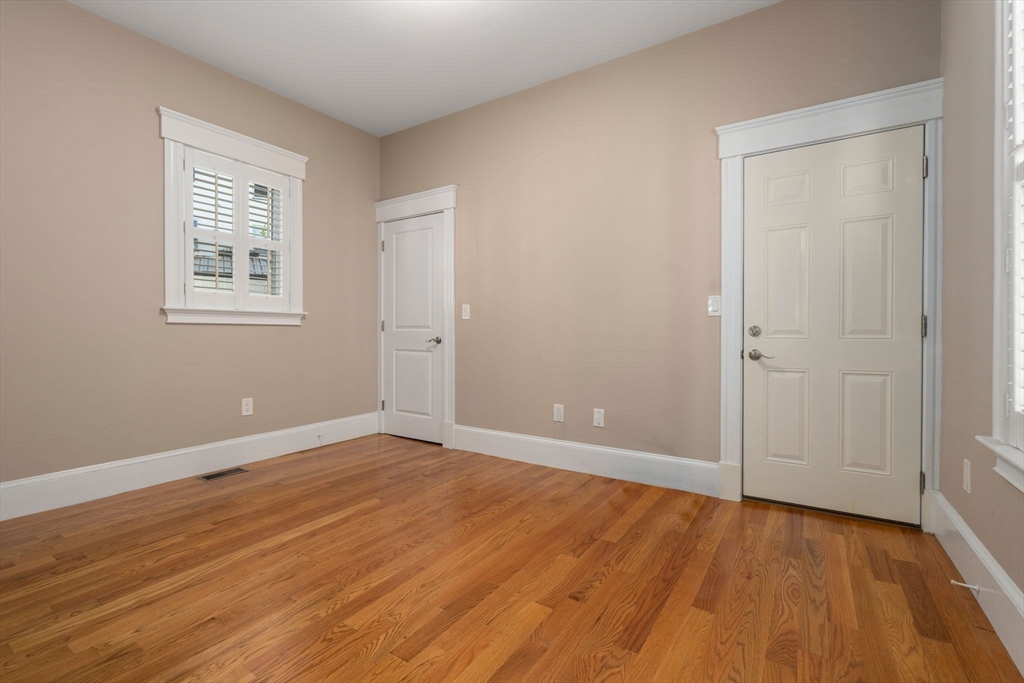 19 Pinckney Street, Unit 1 Somerville, MA 02145 - Photo 16 of 39 an empty room with wooden floor and windows