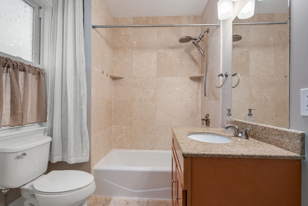 19 Pinckney Street, Unit 1 Somerville, MA 02145 - Photo 22 of 39 a bathroom with a granite countertop sink toilet and shower
