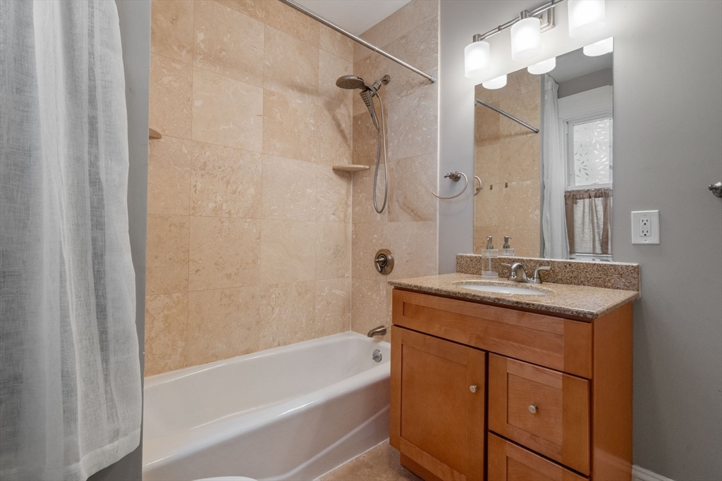 19 Pinckney Street, Unit 1 Somerville, MA 02145 - Photo 23 of 39 a bathroom with a granite countertop sink mirror toilet and bathtub