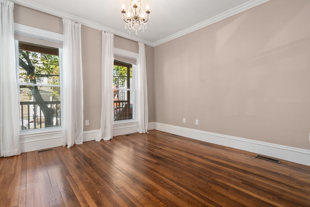 19 Pinckney Street, Unit 1 Somerville, MA 02145 - Photo 29 of 39 a view of an empty room with wooden floor and a window