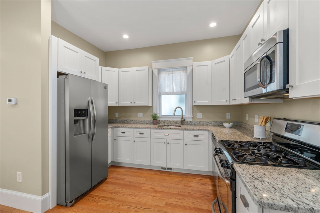 19 Pinckney Street, Unit 1 Somerville, MA 02145 - Photo 8 of 39 a kitchen with stainless steel appliances granite countertop a stove a refrigerator and a sink