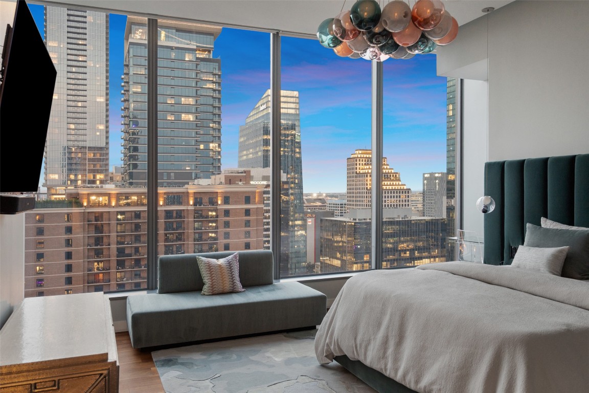 210 Lavaca Street, Unit 2505 Austin, TX 78701 - Photo 27 of 40 a bedroom with a large bed and a chandelier