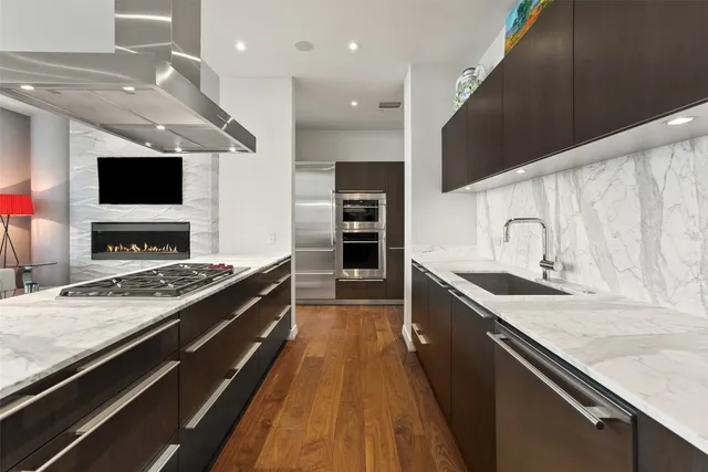 a large kitchen with stainless steel appliances granite countertop a stove and a sink