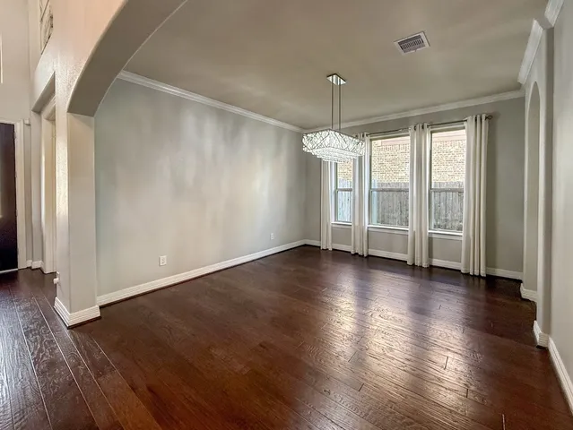 an empty room with wooden floor and window