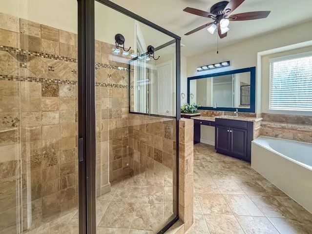 a bathroom with a granite countertop sink a mirror and shower